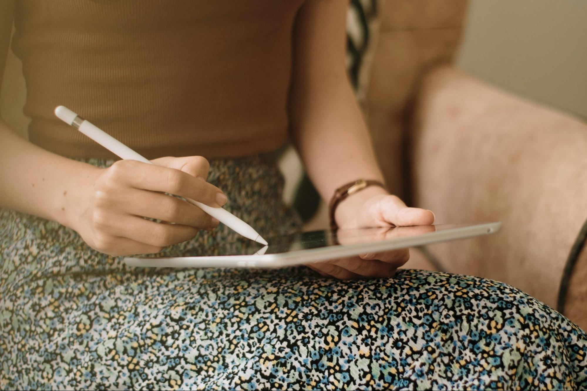 A woman writing on iPad